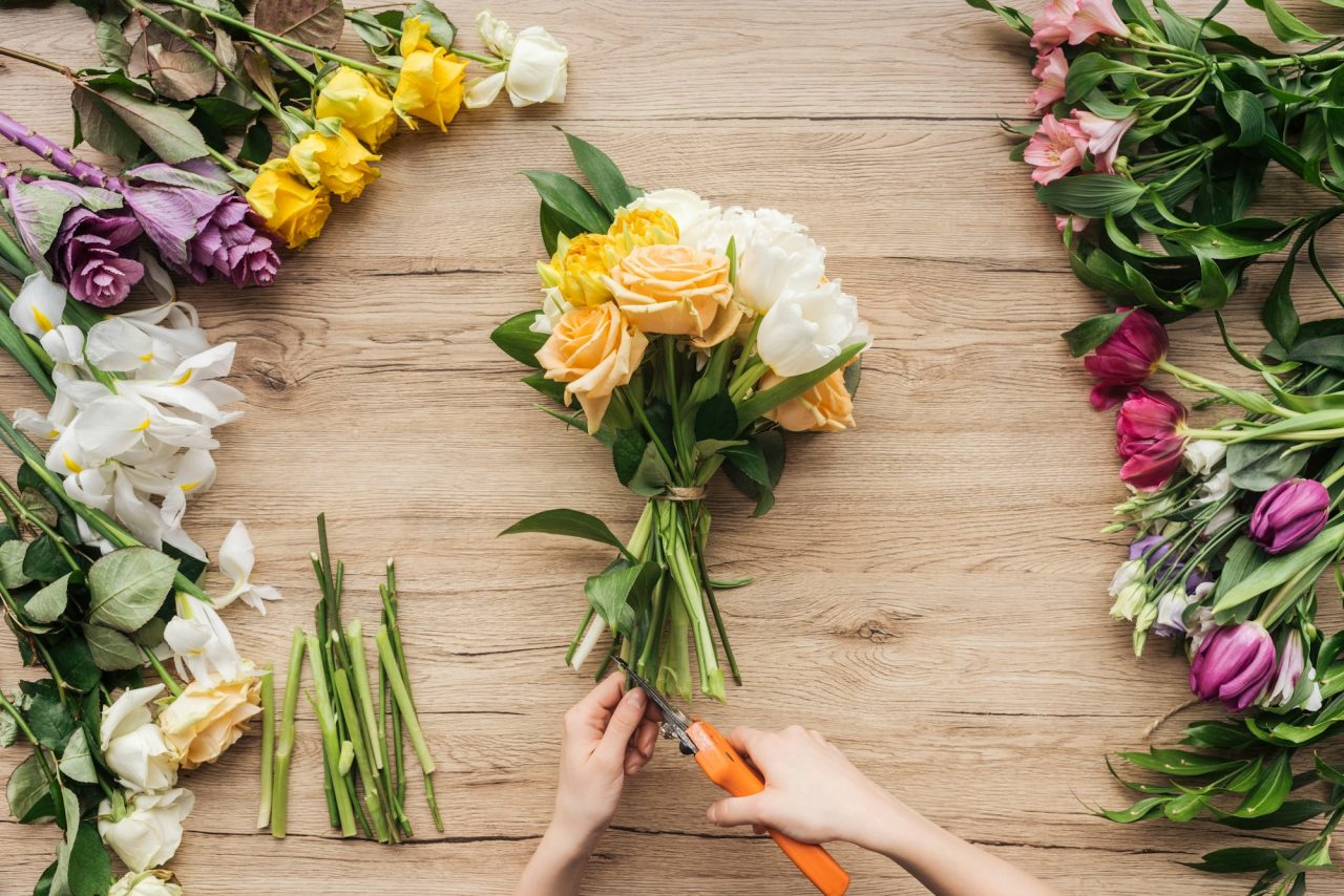 cropped-view-of-florist-cutting-flower-stalks-in-bouquet-on-wooden-surface.jpg